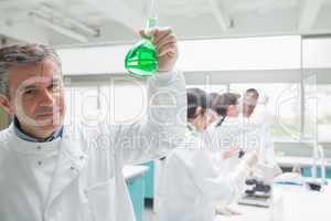 Chemist happily holding beaker