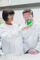 Chemists viewing green liquid