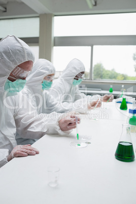 Chemists adding liquid to petri dish