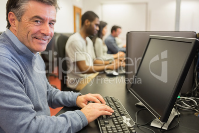 Smiling man sitting in front of the computer