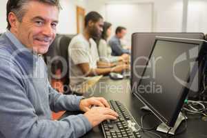 Smiling man sitting in front of the computer