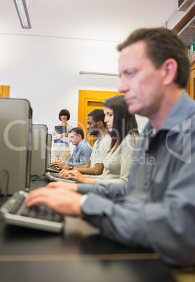 Teacher smiling while others working