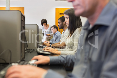Teacher helping her students in computer class