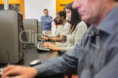 Teacher standing at front of computer class