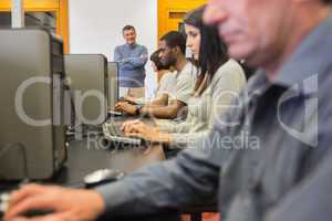 Teacher standing at front of computer class