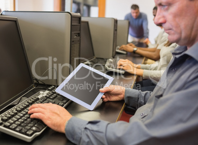 Man in computer class looking at tablet pc