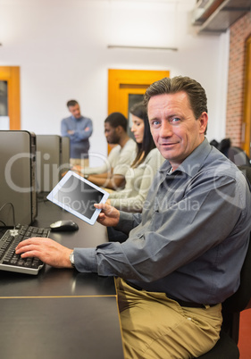 Mature student in computer class holding tablet pc