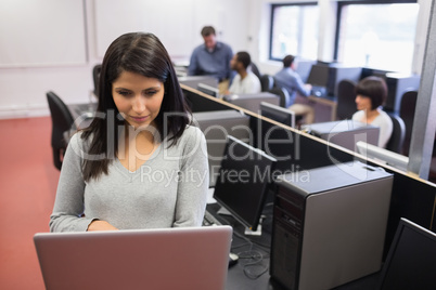Woman typing on laptop in class