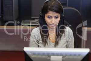 Black-haired woman concentrating on computer