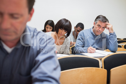Man looking up from taking notes