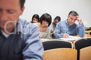 Man looking up from taking notes