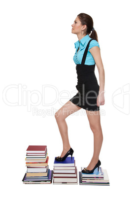 Young woman climb on stairs of books