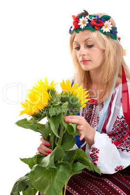 Woman wears Ukrainian dress is holding a sunflower
