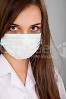 Doctor / nurse smiling behind surgeon mask. Closeup portrait of
