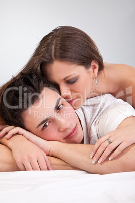 Portrait of happy young couple lying in bed and smiling