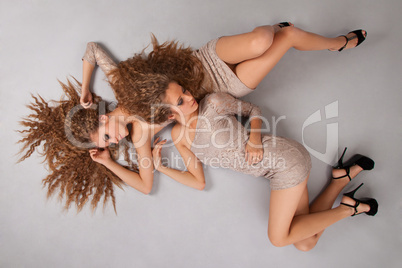 Two girls twins, isolated on the grey background