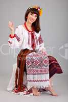 Attractive woman wears Ukrainian national dress is sewing