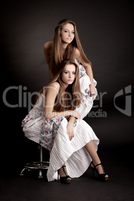 Two girls twins, isolated on the grey background