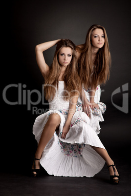 Two girls twins, isolated on the grey background