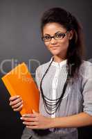 Beautiful student girl is holding an orange book