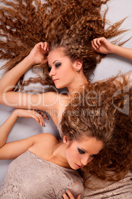 Two girls twins, isolated on the grey background