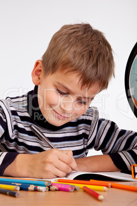 Cute schoolboy is writting