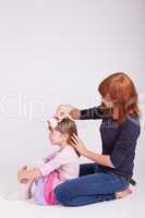 Die Mutter bürstet der Tochter die Haare