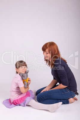 Mutter und Tochter spielen mit einem Stofftier