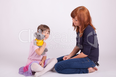 Mutter und Tochter spielen mit einem Stofftier