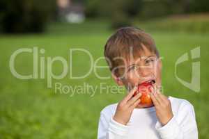 Kind isst einen Apfel