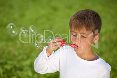 Kleiner Junge macht Seifenblasen