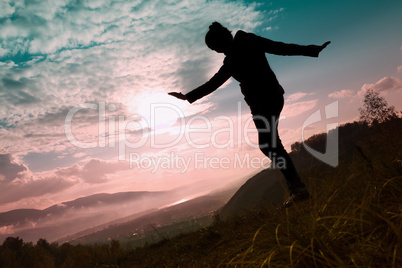 Happy young woman on a sunset sky