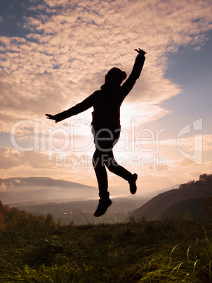 Happy young woman jumping at the sunset