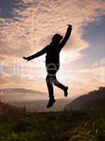 Happy young woman jumping at the sunset