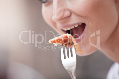 junge frau beim essen einer pizza in einem restaurant im Sommer