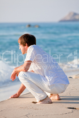 Junger mann entspannt am Strand am Wasser im Sommer