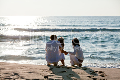 glückliche junge familie mit kleiner Tochter am Strand am wasse