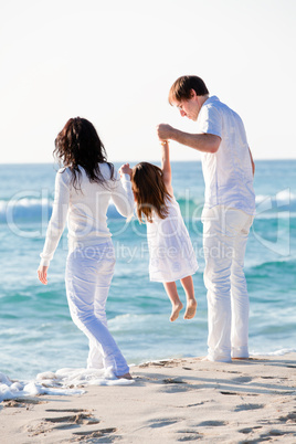 glückliche junge familie mit kleiner Tochter am Strand am wasse