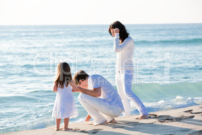 glückliche junge familie mit kleiner Tochter am Strand am wasse