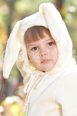 beautiful little girl in costume bunny in the autumn forest