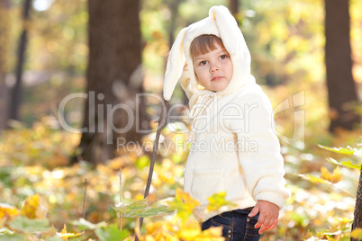 beautiful little girl in costume bunny in the autumn forest