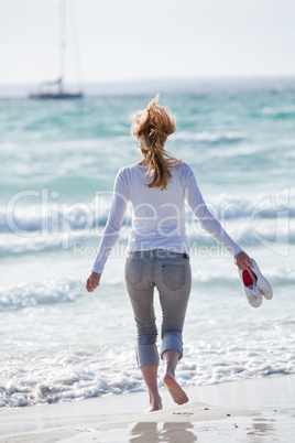 junge hübsche frau spaziert am strand im sand im freien im Somm