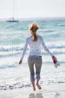 junge hübsche frau spaziert am strand im sand im freien im Somm