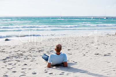 Junger mann entspannt am Strand am Wasser im Sommer