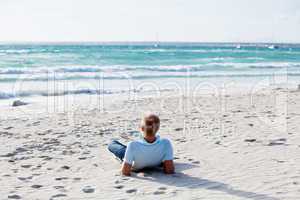 Junger mann entspannt am Strand am Wasser im Sommer