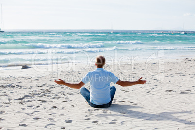 Junger mann entspannt am Strand am Wasser im Sommer