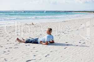 Junger mann entspannt am Strand am Wasser im Sommer