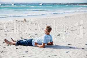 Junger mann entspannt am Strand am Wasser im Sommer