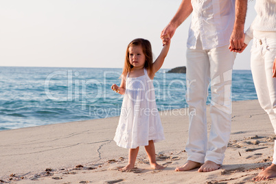 glückliche junge familie mit kleiner Tochter am Strand am wasse