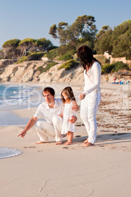 glückliche junge familie mit kleiner Tochter am Strand am wasse